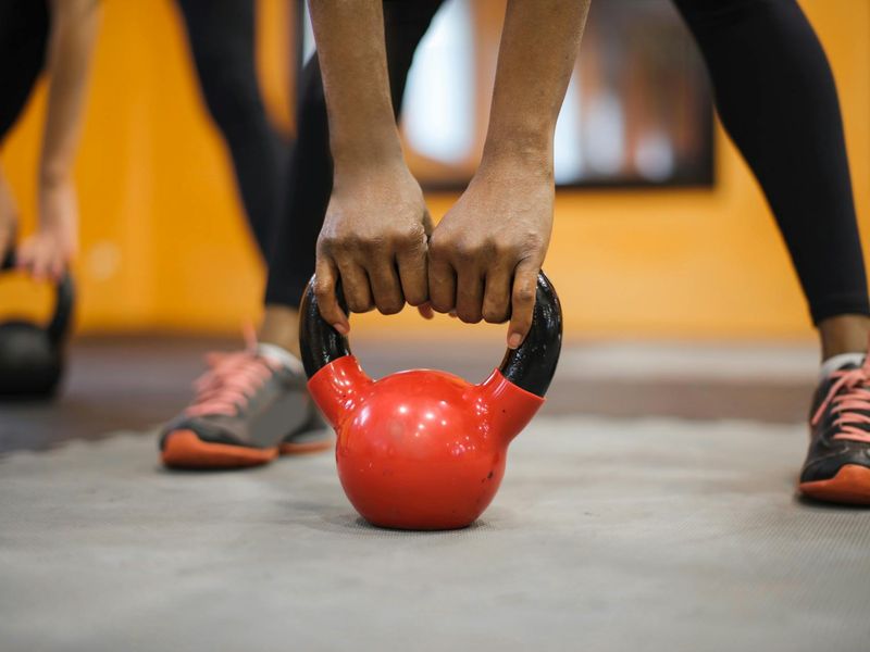 Close up of a heavy kettlebell on a wooden floor.