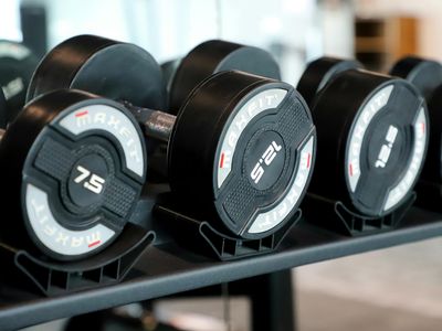 Dumbbells resting on a rack in a modern gym.