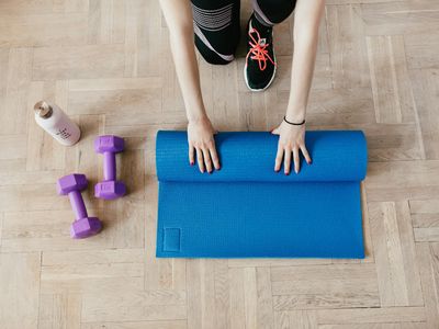 Minimalist yoga mat and water bottle on floor.